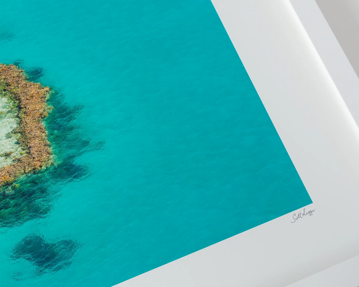 The Heart. Aerial view of Heart Reef, Great Barrier Reef, Queensland, with a white frame on a table.