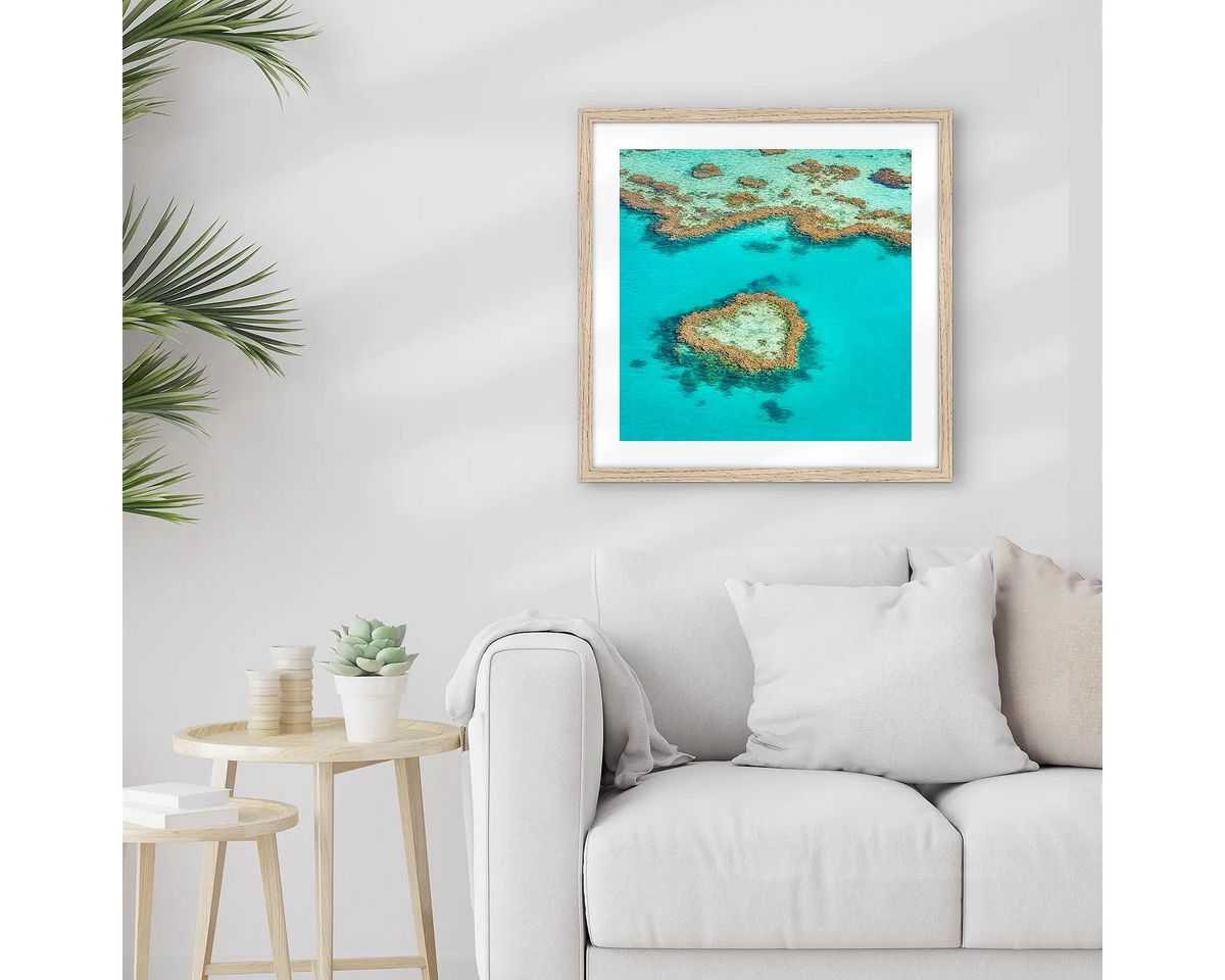 The Heart. Framed Great Barrier Reef wall art print, with a timber frame, hung above a couch.