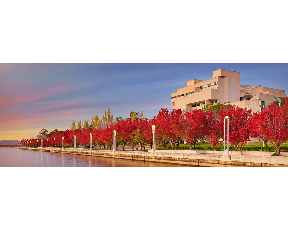 The High Court of Australia photographed at sunrise with Lake Burley Griffin and red trees in the foreground, Canberra, ACT. 