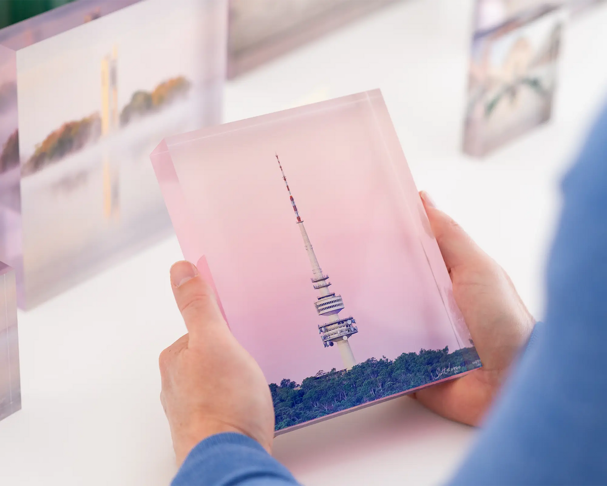 The Needle. Acrylic block of Telstra tower and Black mountain tower with a pink sunset. Canberra artwork being held.