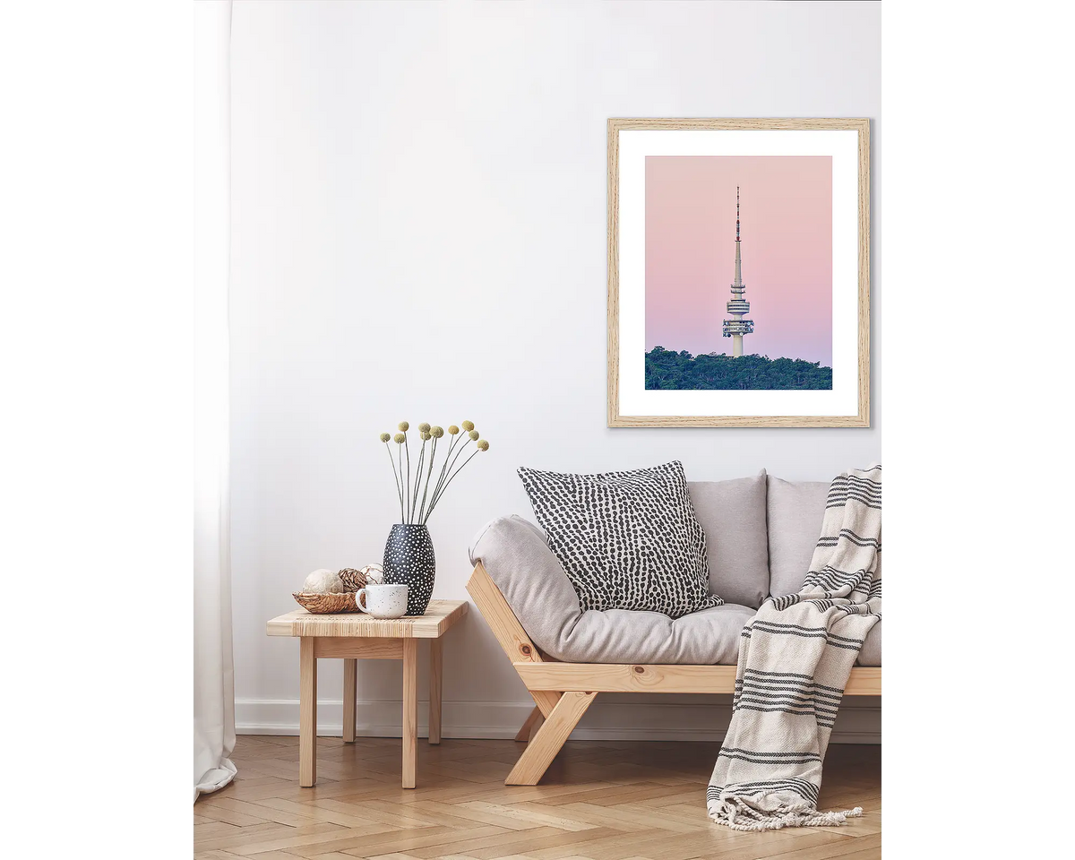 The Needle. Canberra wall art print in a Tasmanian Oak frame, hanging above a couch.