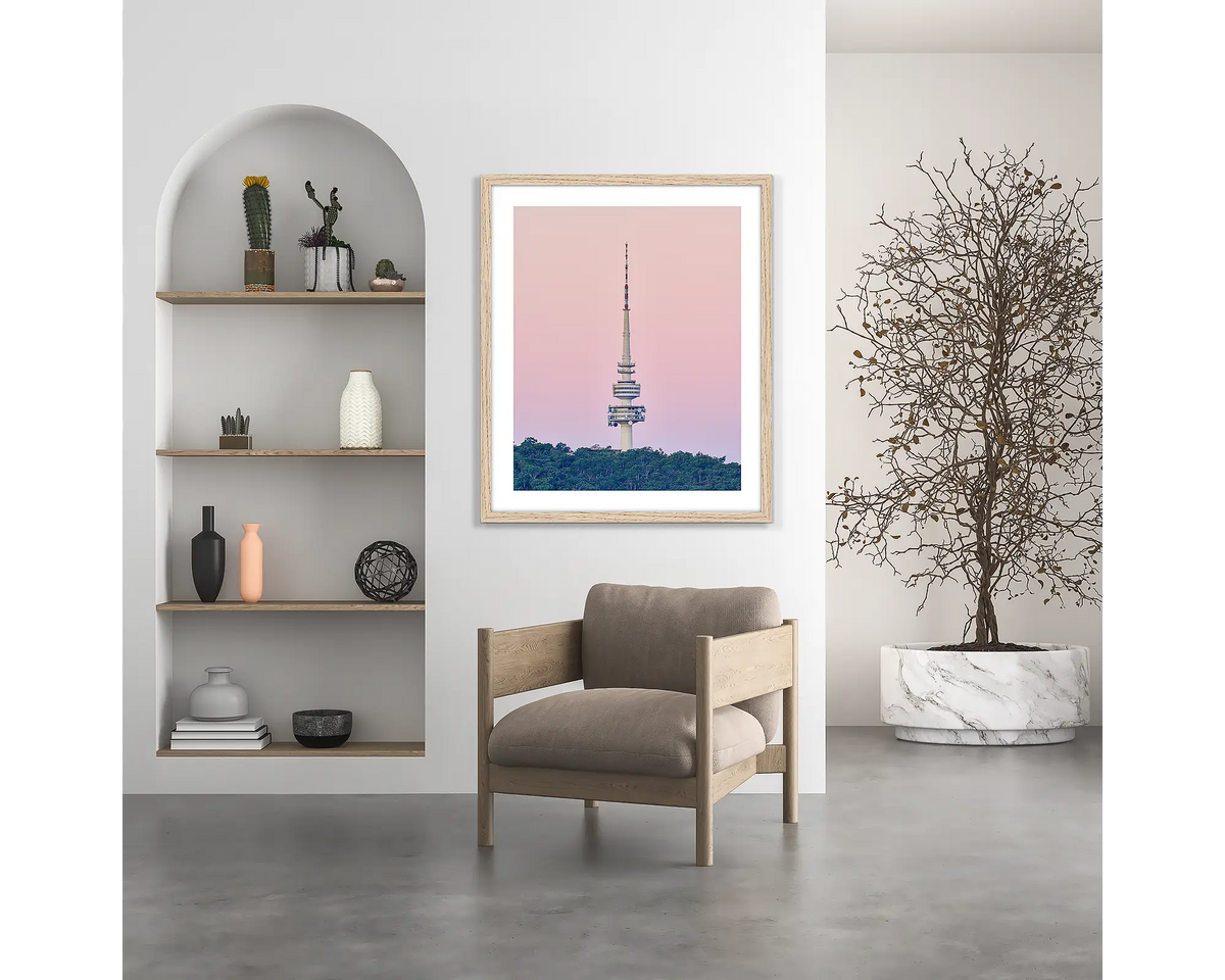 The Needle. Telstra Tower, Canberra wall art print, with a wood frame, hung above a chair.