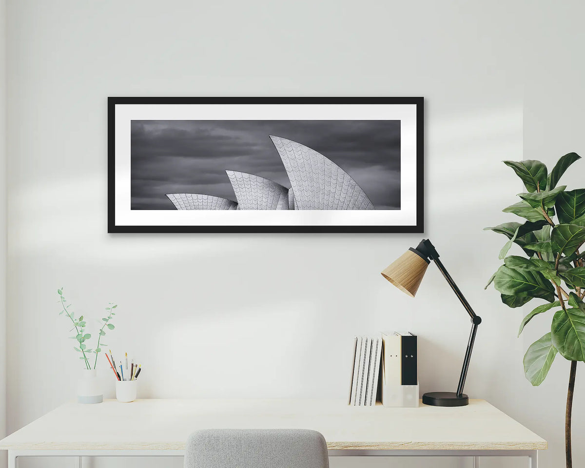 Three Sails. Sydney Opera House wall art print, with a black frame, hung above a home office desk. 