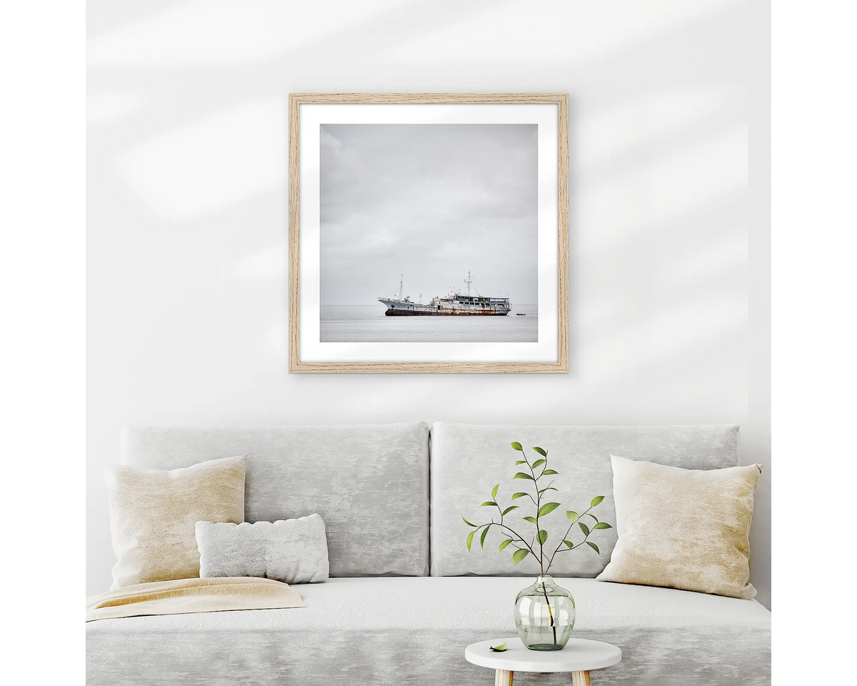 Uncertainty. Old boat wall art print with wood frame hung above couch.