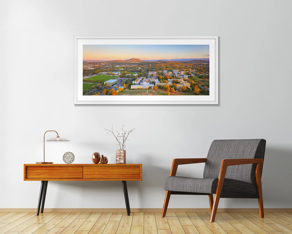 University Sunset. University Of Canberra wall art print with white frame above chair.