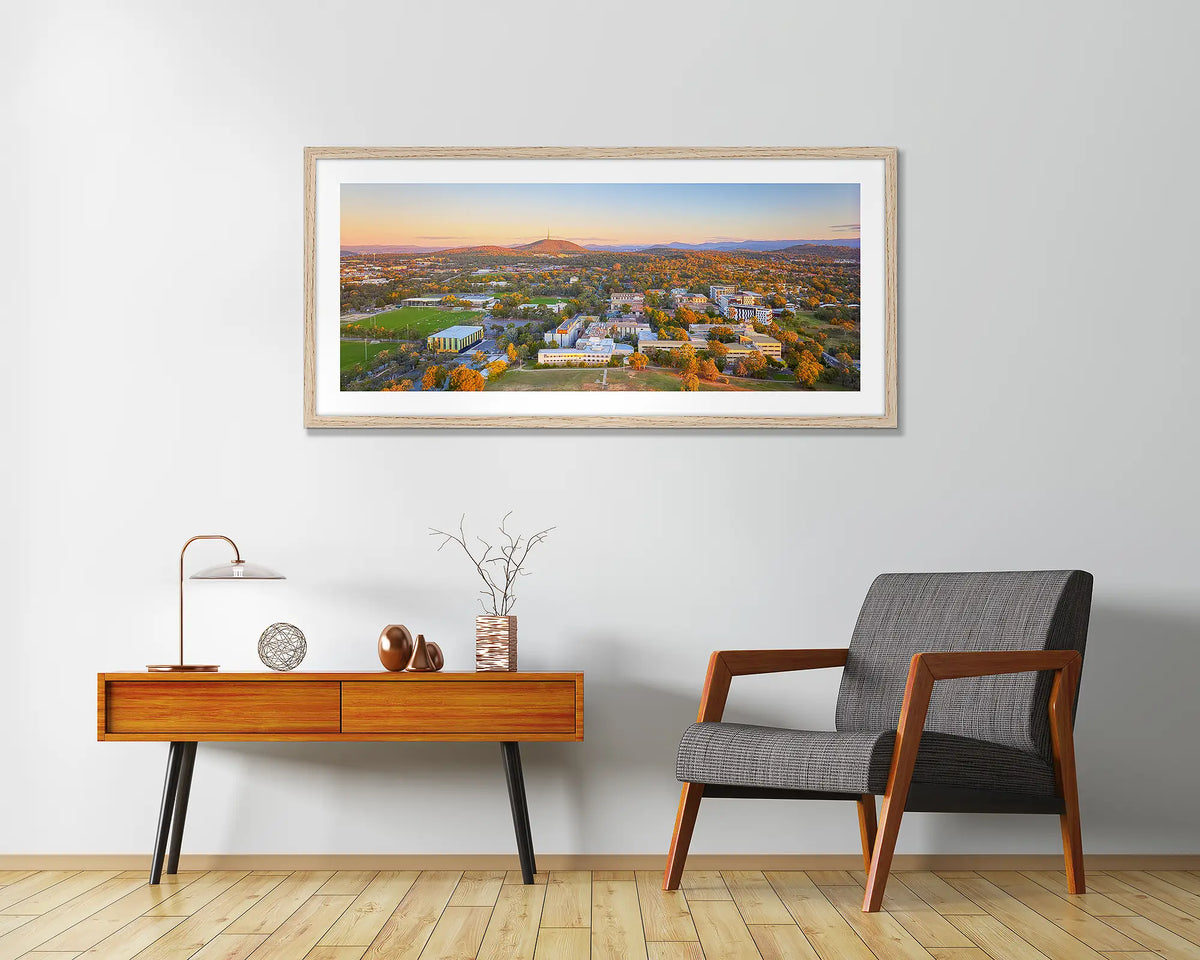 University Sunset. University of Canberra wall art print, with a wood frame, above a chair.