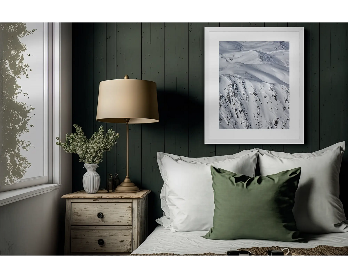 Unveiled. Framed, snow wall art print, in a white frame, hanging on a bedroom wall.