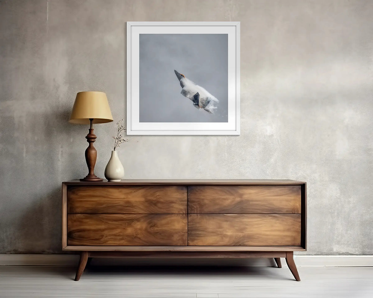 Vector. F-22 Raptor wall art print, with a white frame, above a side table. 