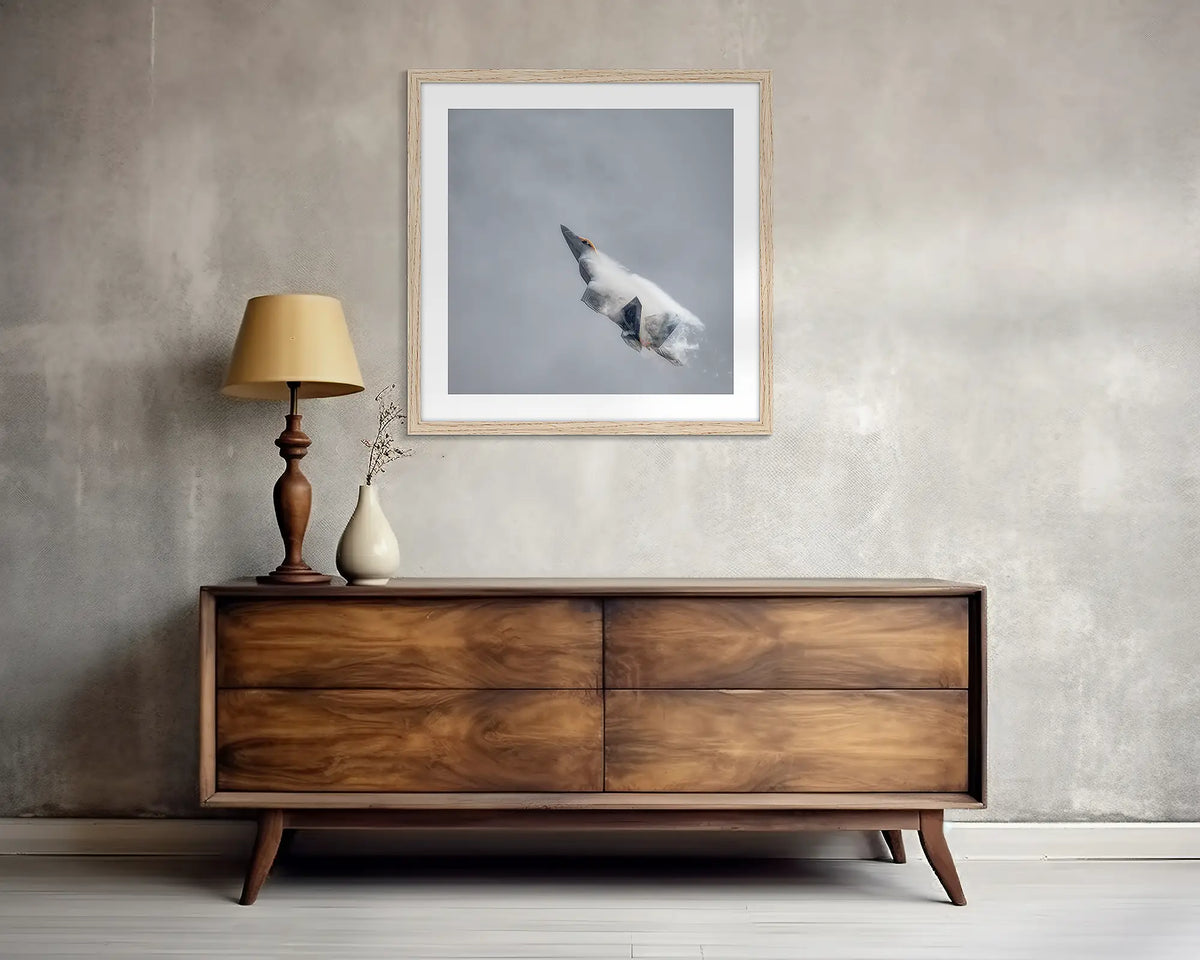 Vector. F-22 Raptor wall art print, with a wood  frame, above a side table. 