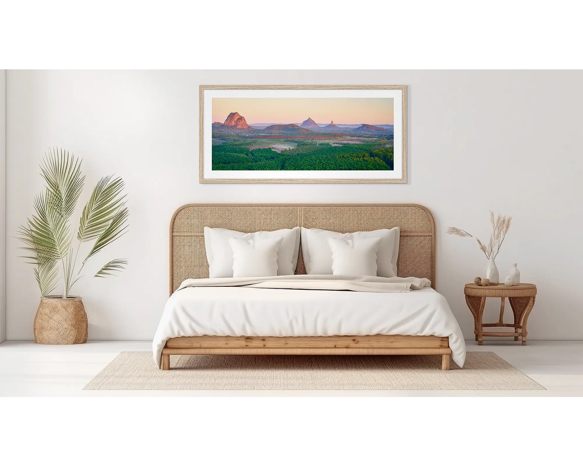 Volcanic Dawn. Glass house mountains artwork, in an oak frame, in a bedroom. 