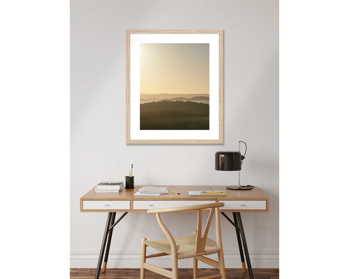 Waniassa Wakes - Canberra sunrise artwork with Tasmanian oak frame, hanging above desk.