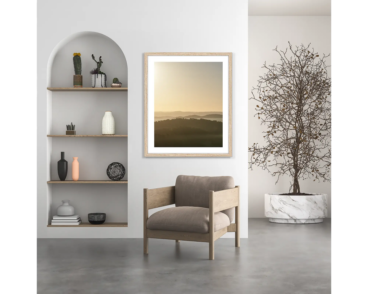 Wanniassa Wakes. Canberra sunrise wall art print, with a wood frame, hung above a chair. 