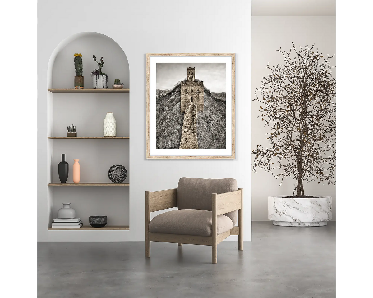 Watchtowers. Great Wall of China wall art print, with a wood frame, hung above a chair. 