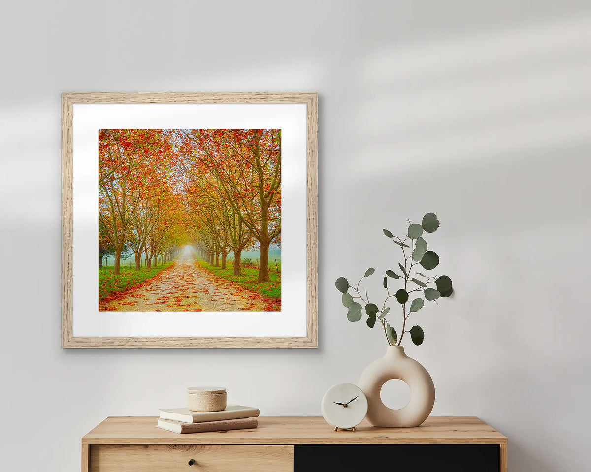 Welcome To Autumn artwork in Tasmanian Oak frame, hanging on wall above table.