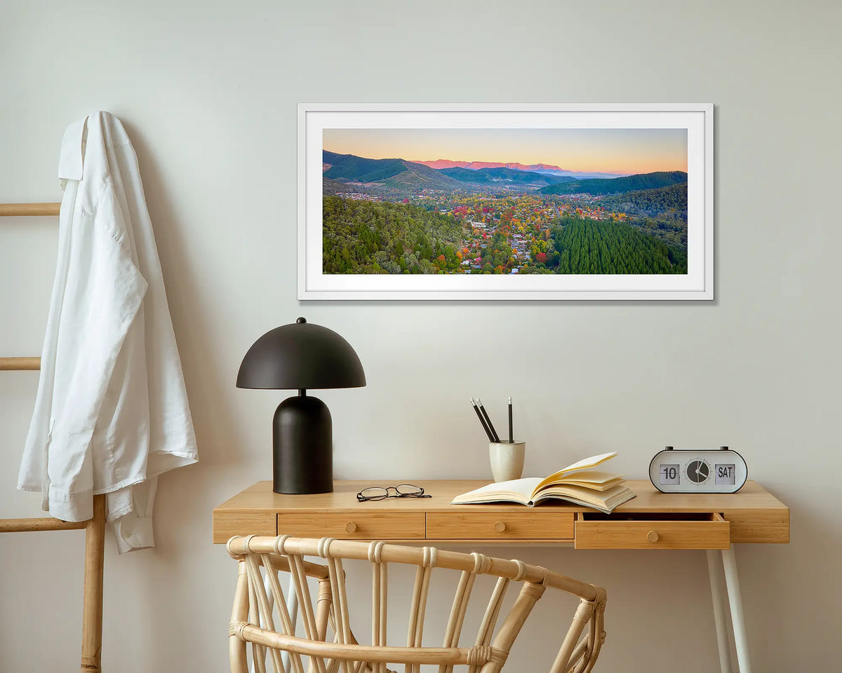 Welcome to Bright wall art print with white frame hung above small desk.