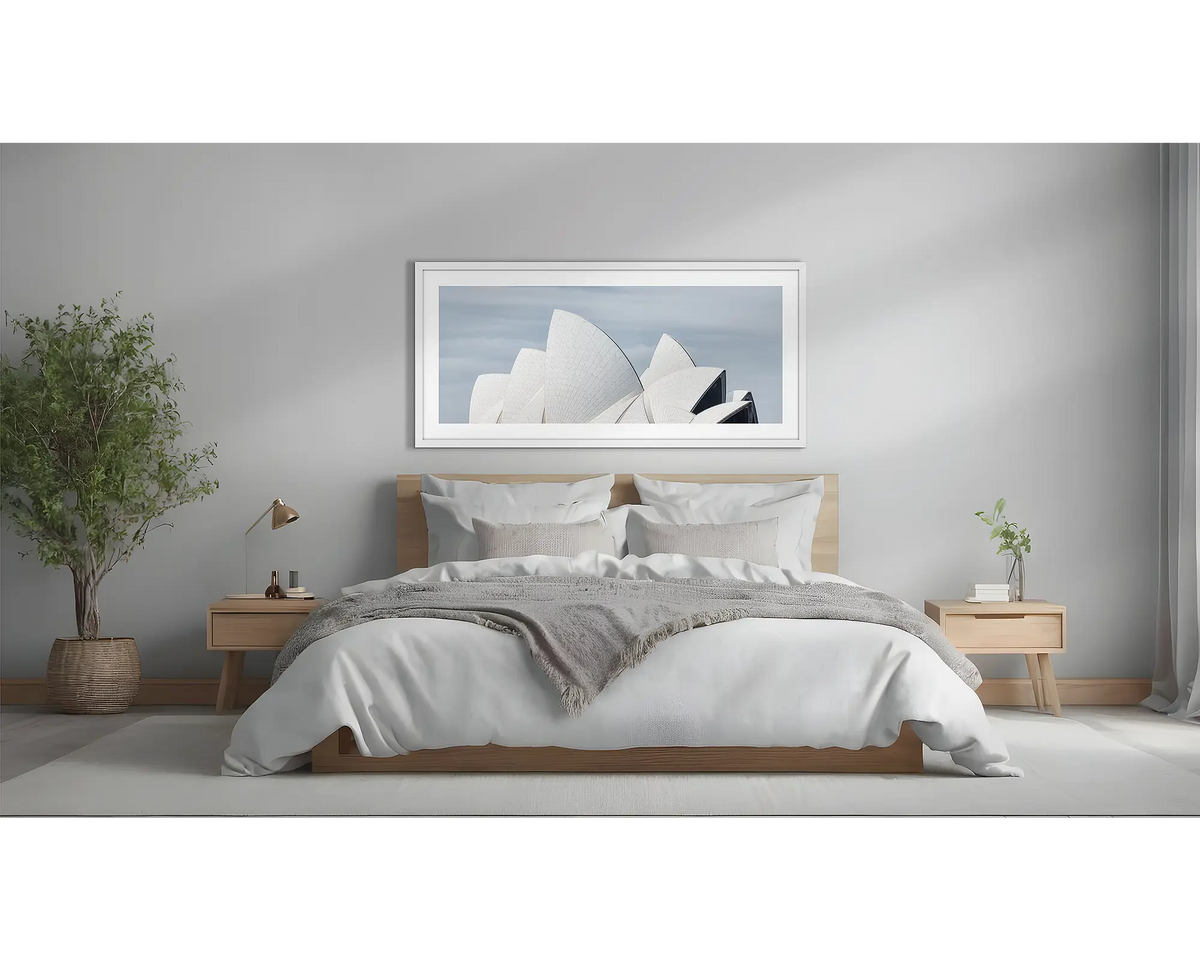 White Sails. Sydney Opera house artwork, with a white frame, hung above a bed. 