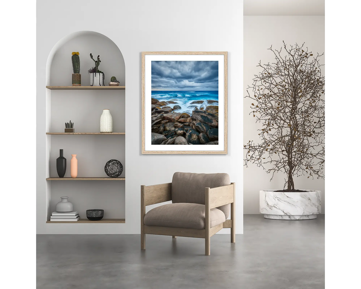 Wild West. Coastal wall art print, with a wood frame, hung above a chair. 