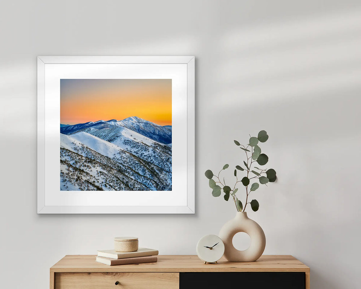 Winter Glow wall art print in white frame above a table.