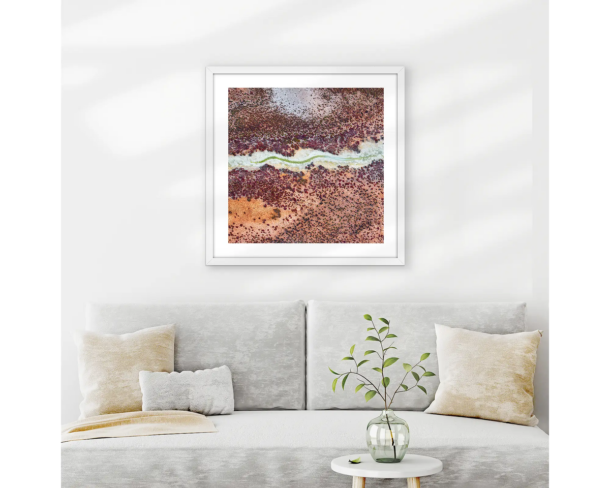 Wriggle. Abstract Kimberley wall art print with white frame hung above couch.