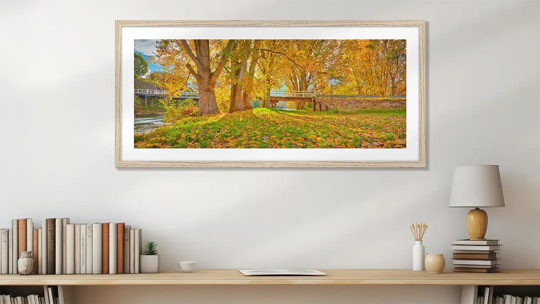 Yellow wall art print with timber frame above desk.